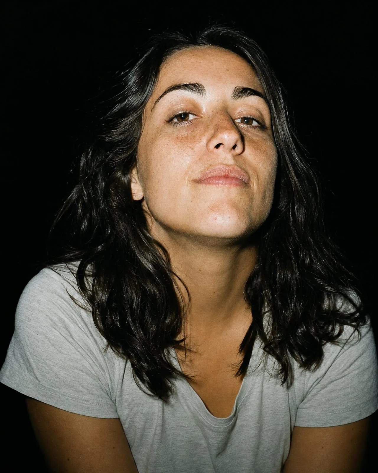 Portrait au flash d'une femme au sourire franc, regardant l'objectif